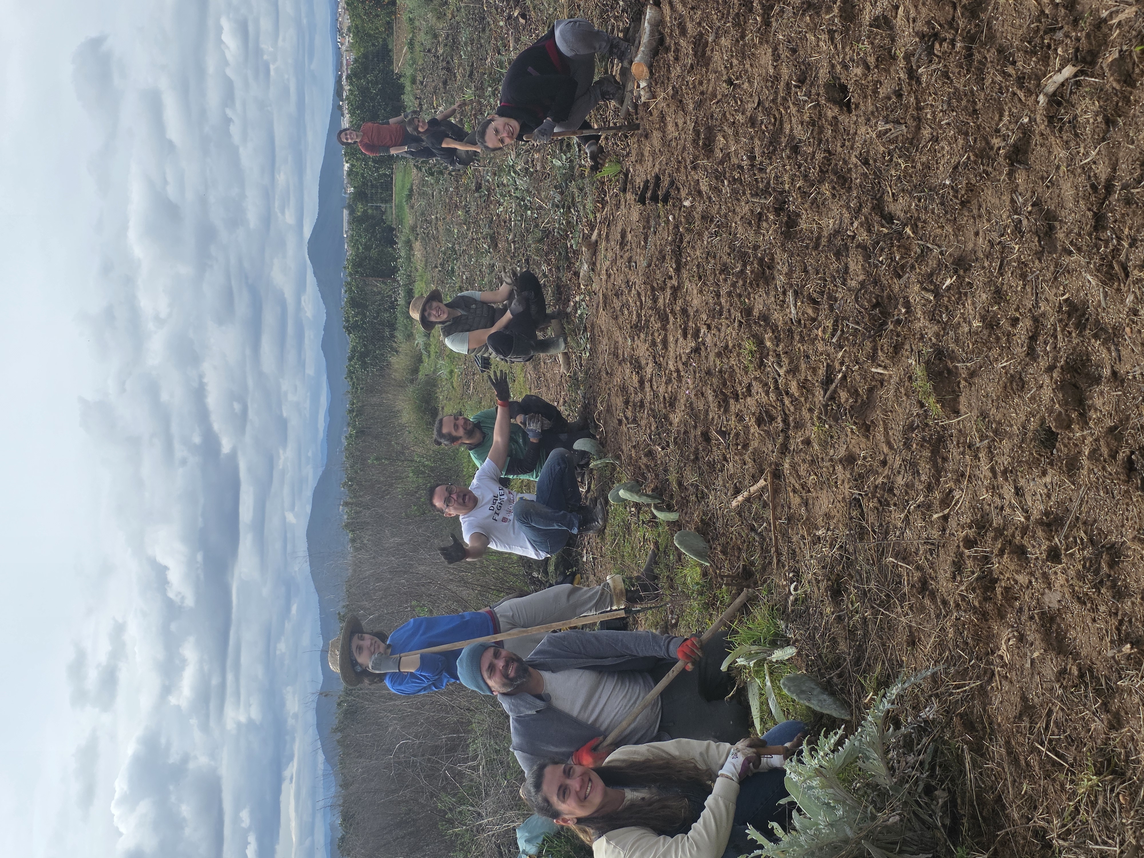 Participantes plantando en el campo durante el curso de diseño de bosques de alimentos en Valencia.